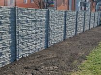 Betónový plot šedý štiepaný kameň so vzorovanými stĺpikmi