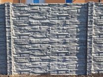 Betónový plot šedý štiepaný kameň so vzorovanými stĺpikmi en face